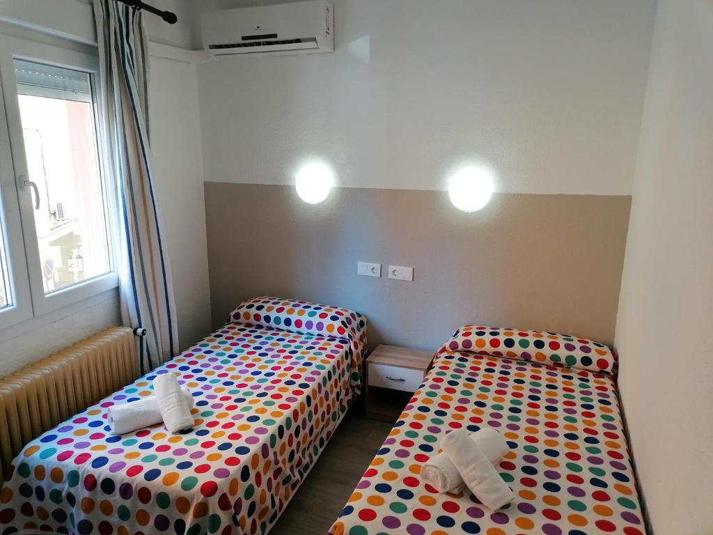 A bed or beds in a room at Hostal Hernan Cortes
