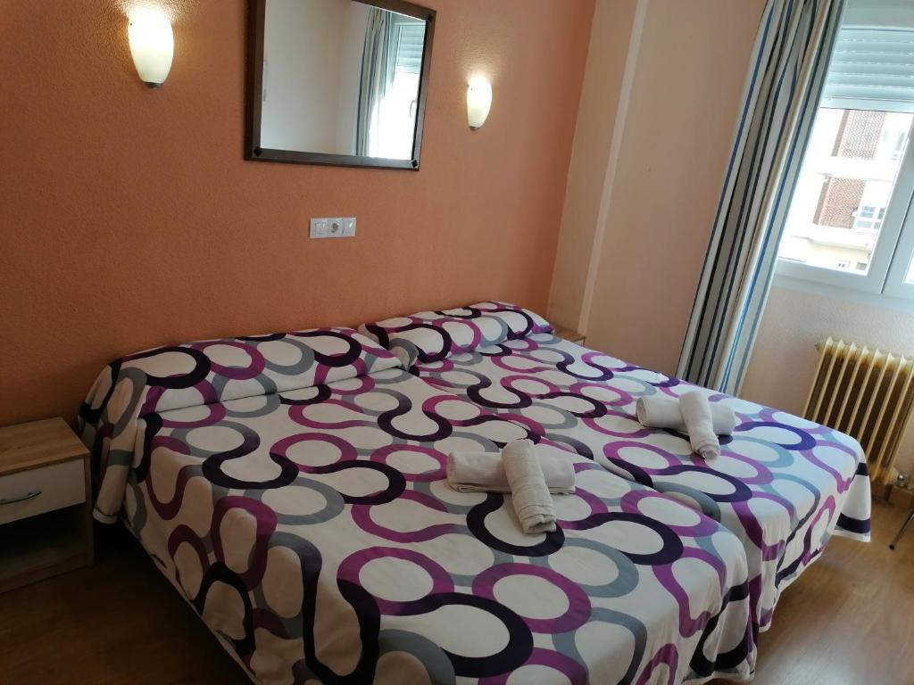 A bed or beds in a room at Hostal Hernan Cortes