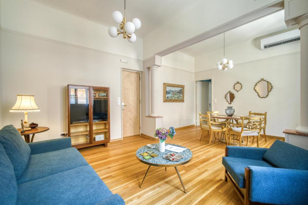 a living room with blue couches and a table at KERAMOS Athens in Athens