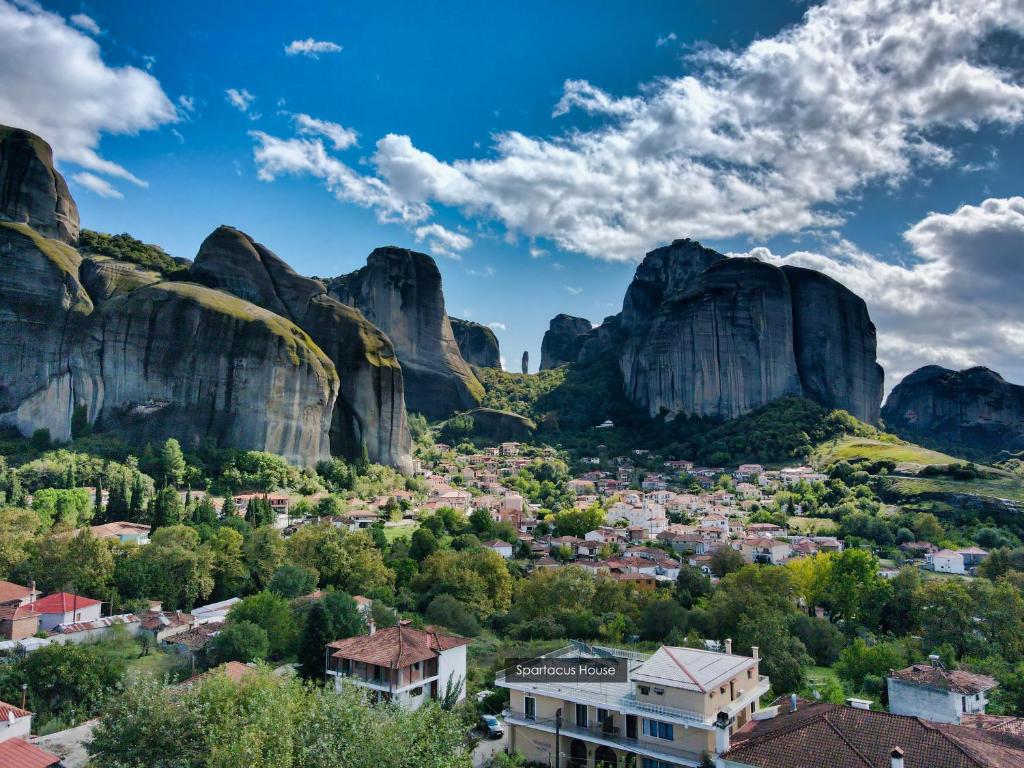 uma vista para uma aldeia entre duas montanhas de meteoria em Spartacus House em Kalabaka