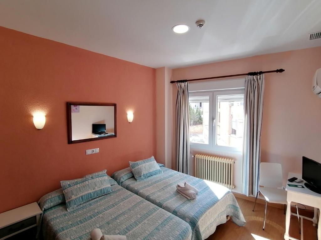 A bed or beds in a room at Hostal Hernan Cortes