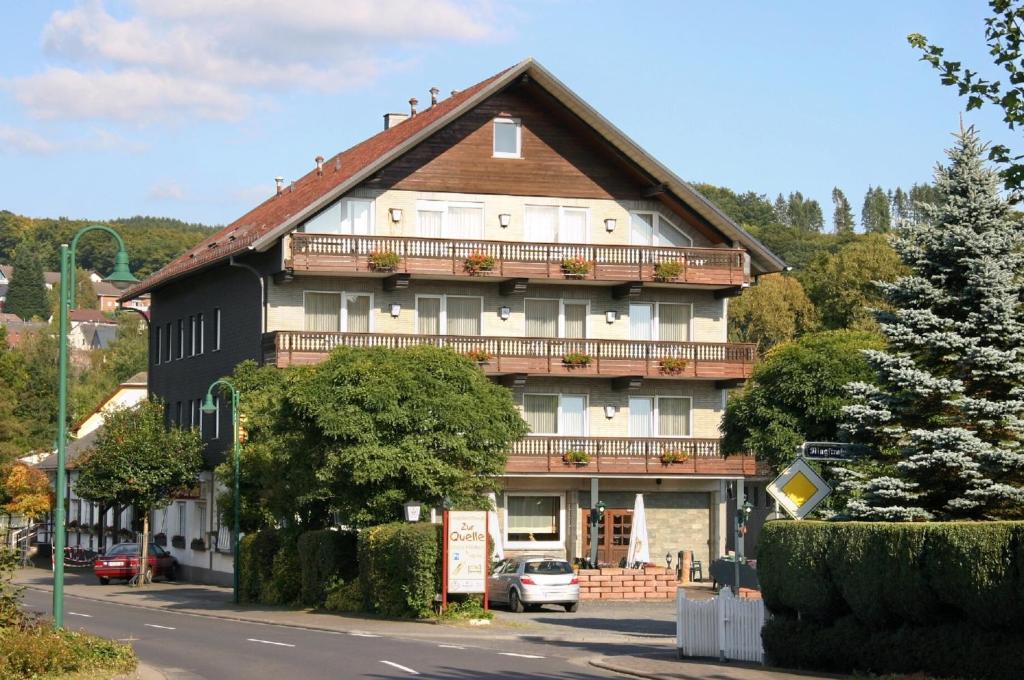 ein großes Gebäude mit Balkon auf einer Straße in der Unterkunft Gasthaus zur Quelle in Bad Marienberg