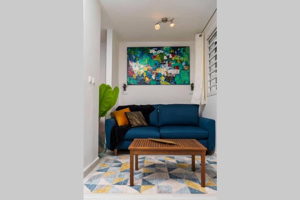 salon z niebieską kanapą i stołem w obiekcie Studio à 5kms de la capitale et porte d'entrée vers Nord Caraïbes w mieście Schœlcher