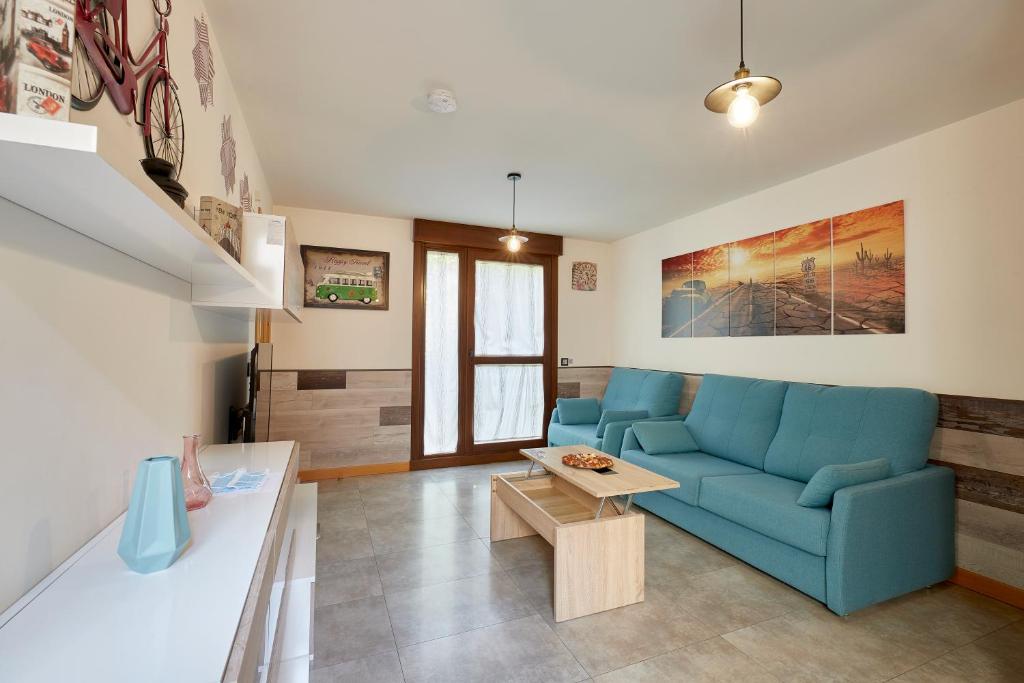 a living room with a blue couch and a table at El Patio de la Catedral in Salamanca