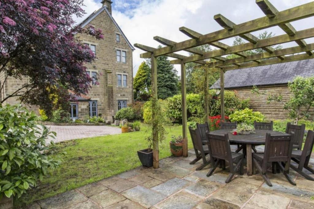 a patio with a table and chairs under a pergola at The Vestry - Chapel Retreat With Hot Tub in Haworth