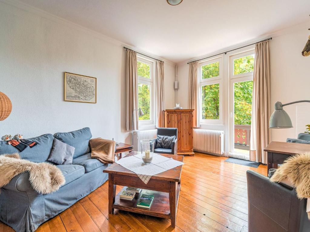 a living room with a blue couch and a table at Gruppenhaus im Harz in Bad Harzburg