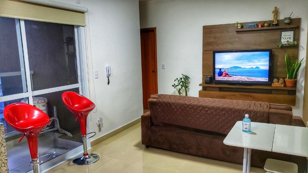 ein Wohnzimmer mit einem Sofa und einem Flachbild-TV in der Unterkunft FRODO-APTO MAGNÍFICO com Wifi , 2 dorm in São Carlos