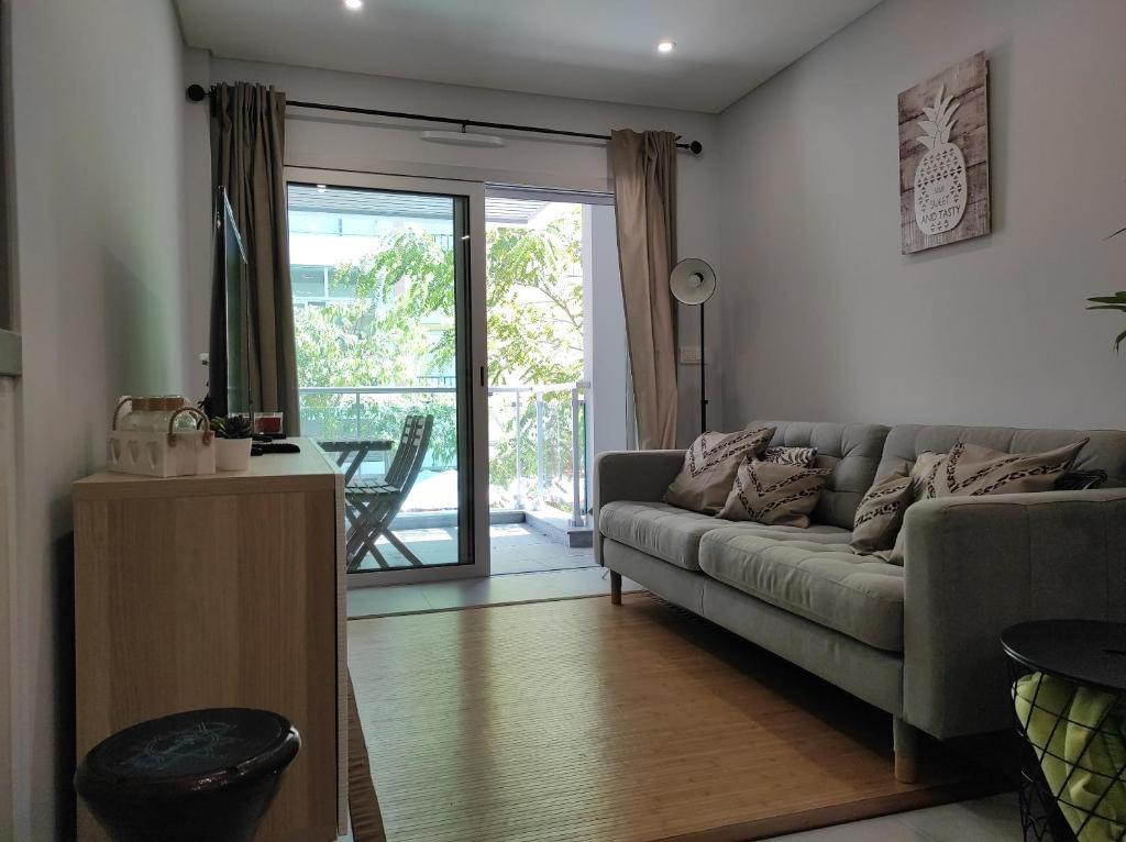 a living room with a couch and a sliding glass door at Eanes 22 beach house in Monte Gordo