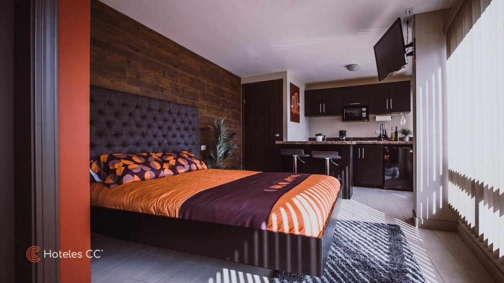 a bedroom with a large bed and a kitchen at Casa Cacho in Tijuana