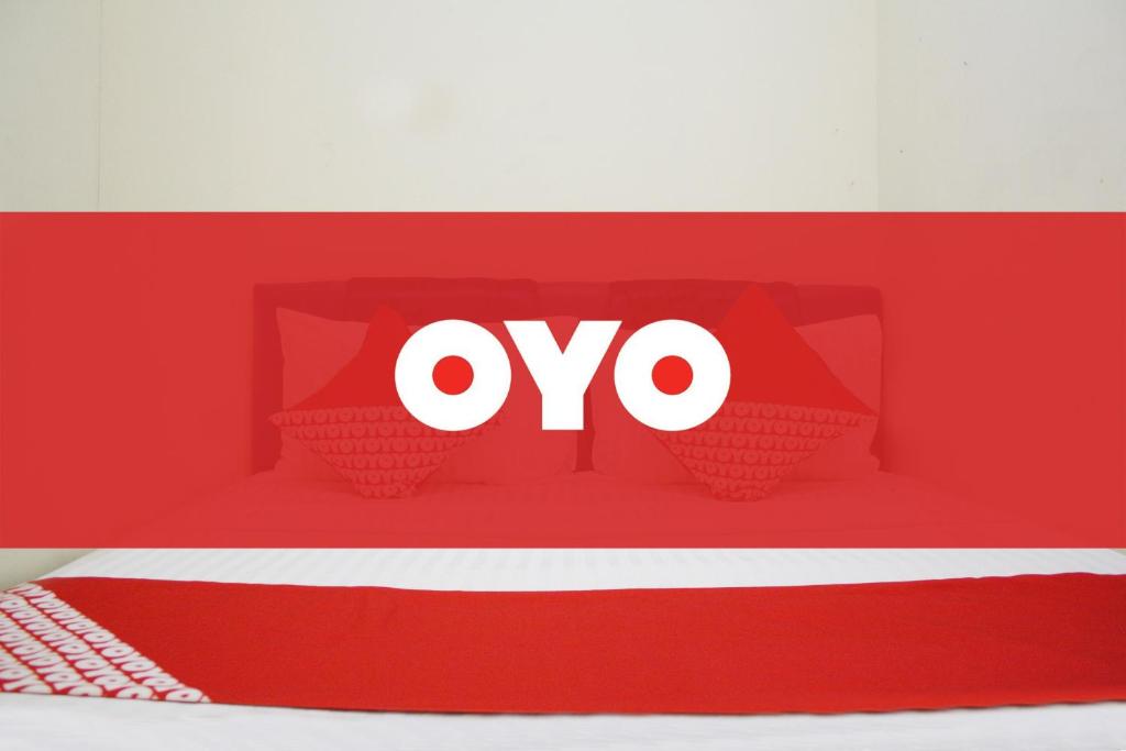 une cabine rouge avec le logo ovo sur elle dans l'établissement OYO Life 2090 Ratna Backpacker Syariah, à Probolinggo