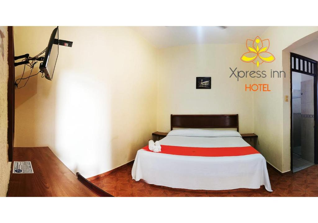 a bed in a room with a hotel sign on the wall at Xpress Inn Hotel in Veracruz