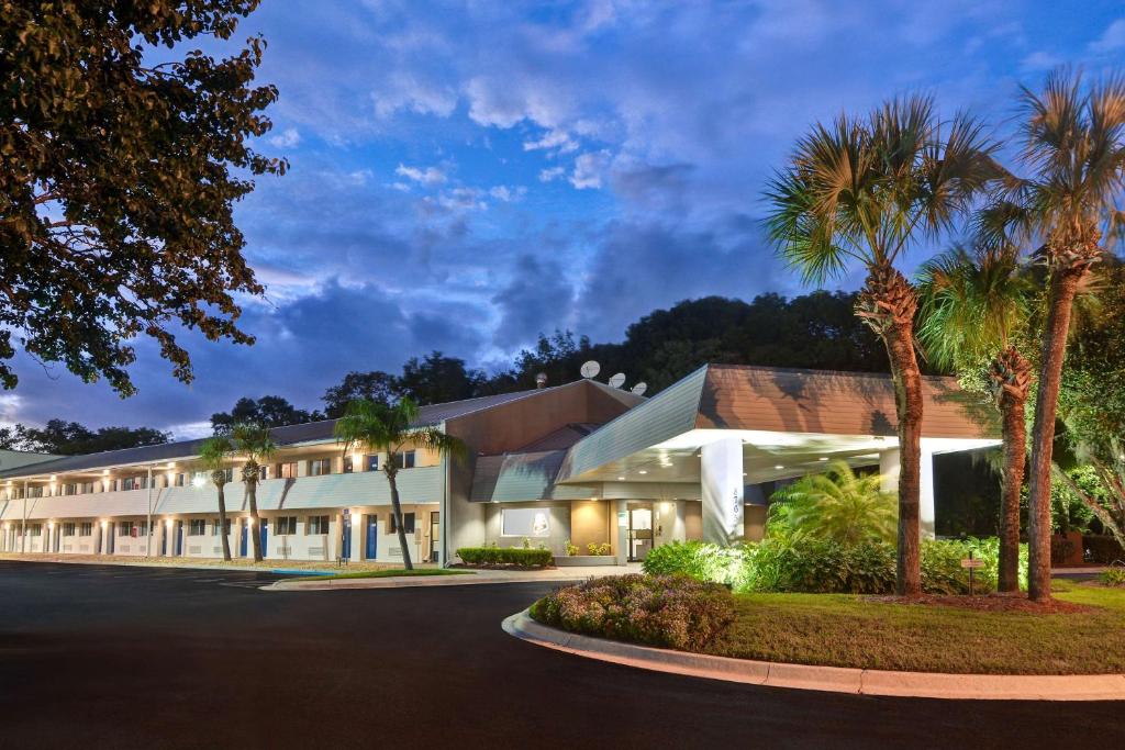 an exterior view of a building with palm trees at Studio 6-Jacksonville, FL - Baymeadows in Jacksonville