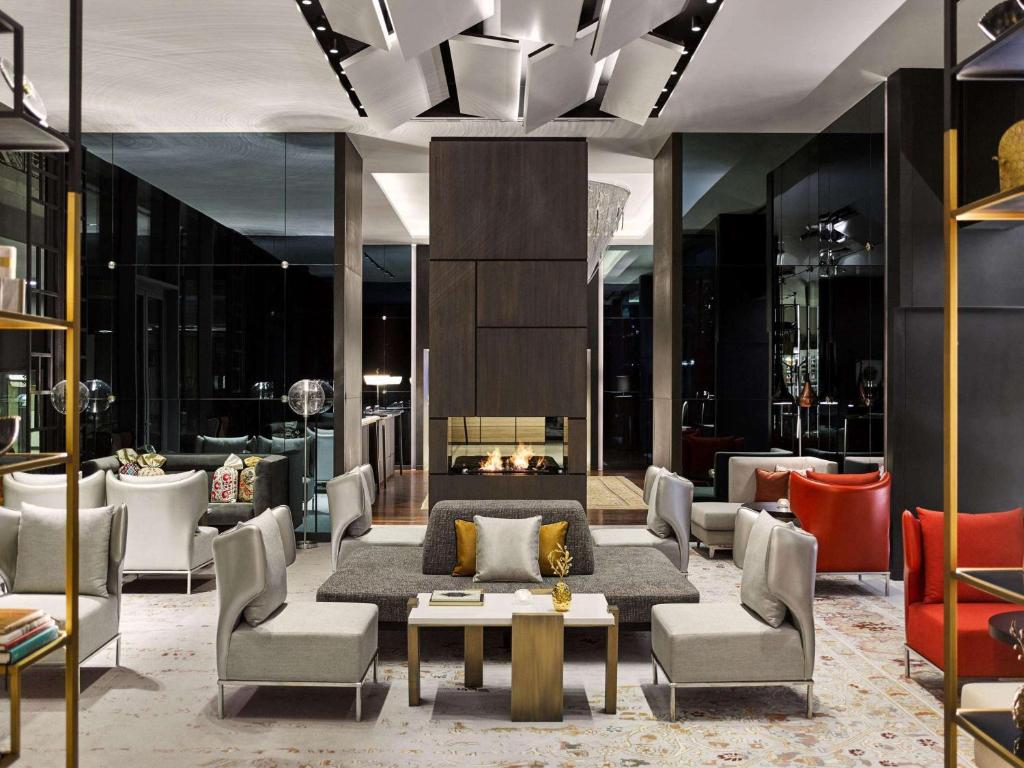 um átrio com um sofá e cadeiras e uma lareira em Fairmont Quasar Istanbul Hotel em Istambul