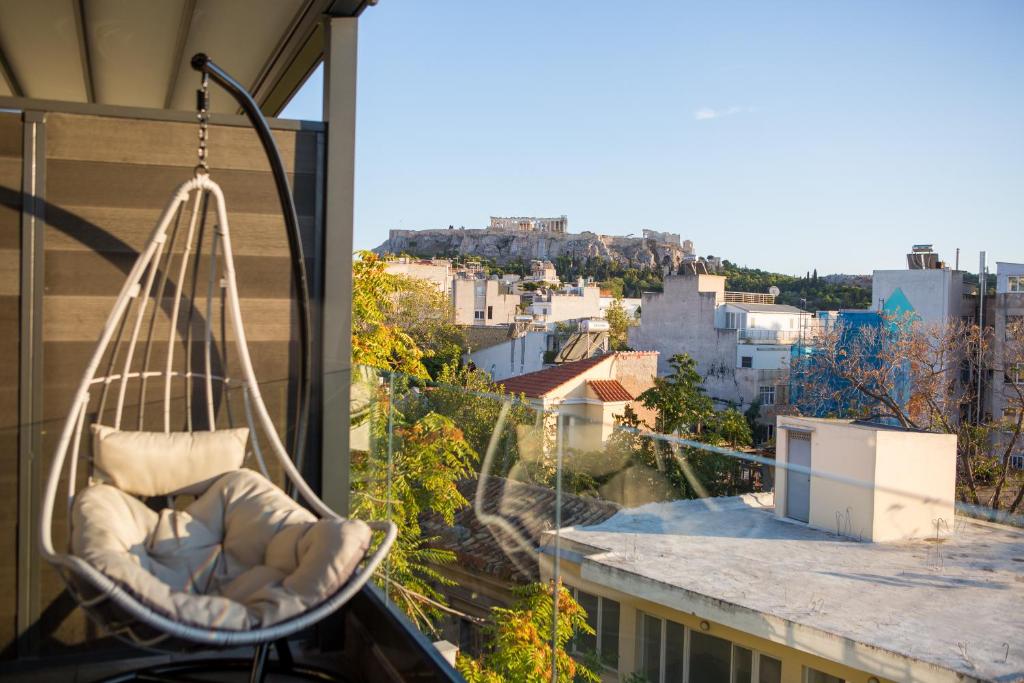 um baloiço pendurado numa varanda com uma cidade em Raise Acropolis View Suites em Atenas