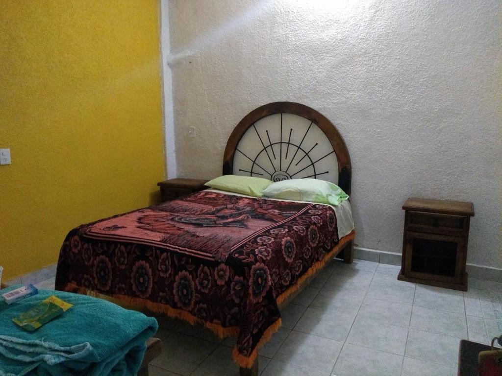 a small bedroom with a bed and a table at Hotel Azucena de Antequera in Oaxaca City