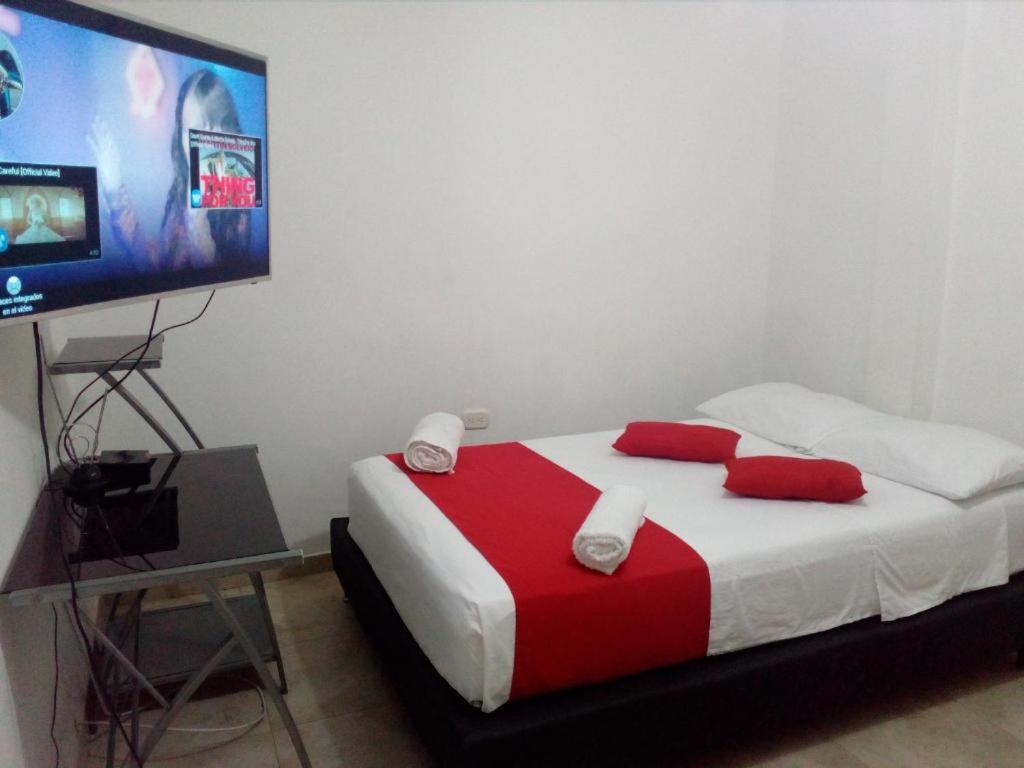 1 dormitorio con 1 cama y TV de pantalla plana en APARTAMENTO MEDELLIN, en Medellín