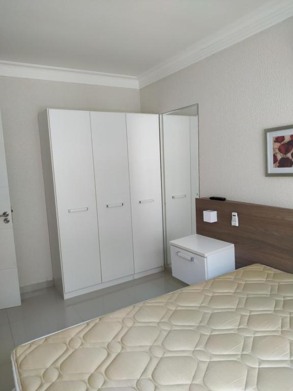 - une chambre avec un lit et des armoires blanches dans l'établissement Vivendas Summer Beach Apto Particular, à Bombinhas