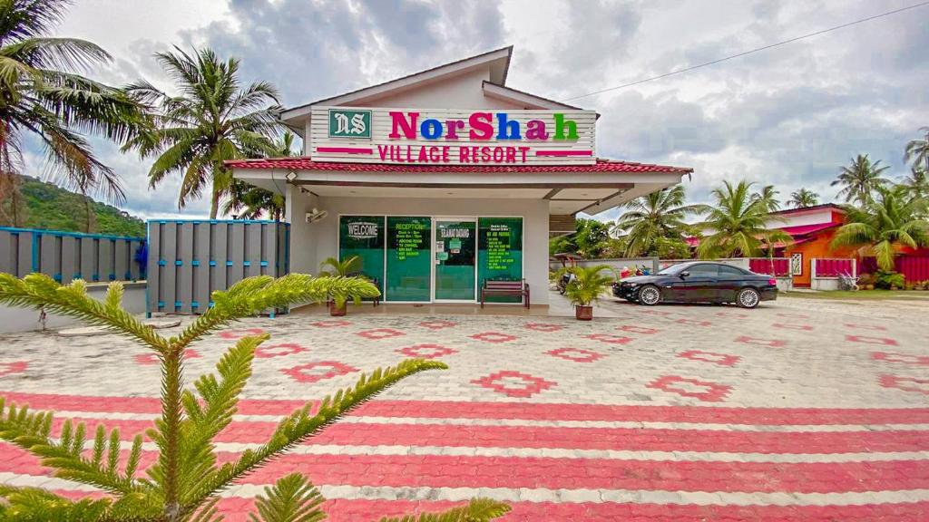 a building with a car parked in front of it at Norshah Village Resort in Pantai Cenang