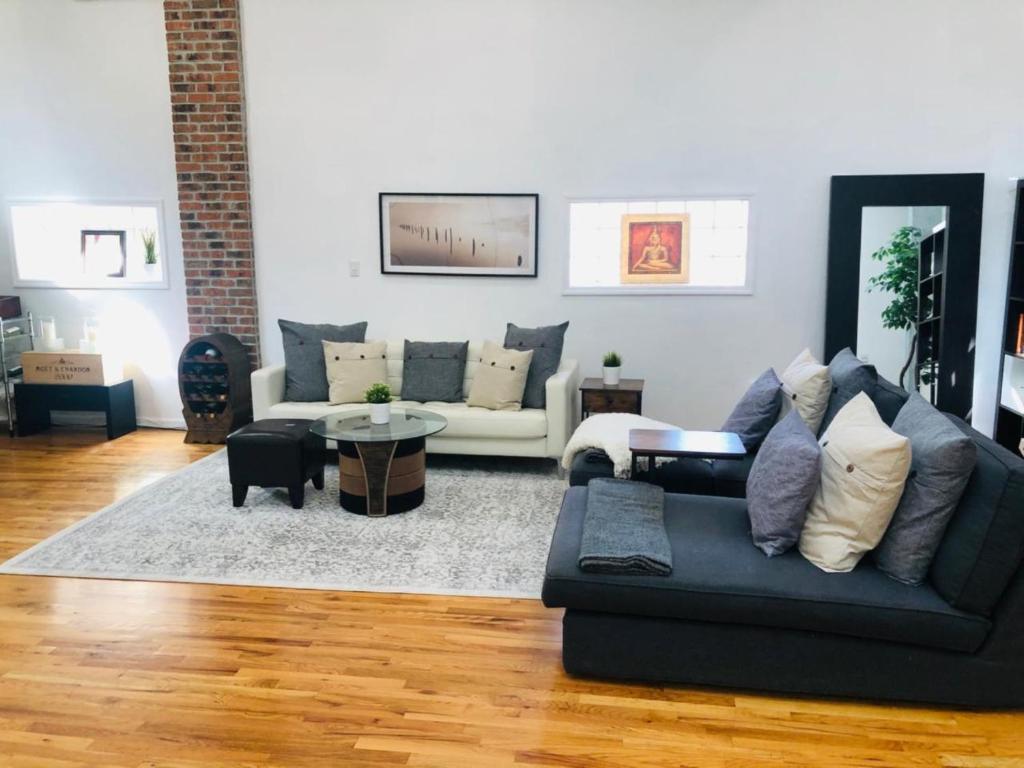 a living room with a couch and a table at UPDATED Amazing Bi -Level Condo minutes from water views of New York City in North Bergen