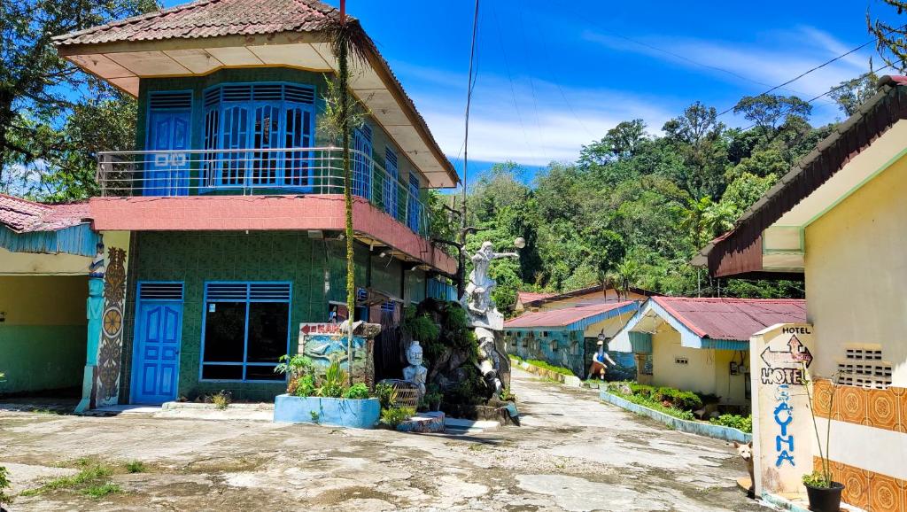 ein Haus mit blauer Tür in einem Dorf in der Unterkunft Hotel Sayna in Sibolangit