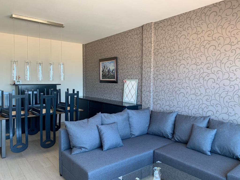 布蘭肯貝赫的住宿－Appartement met zeezicht，客厅配有蓝色的沙发和桌子