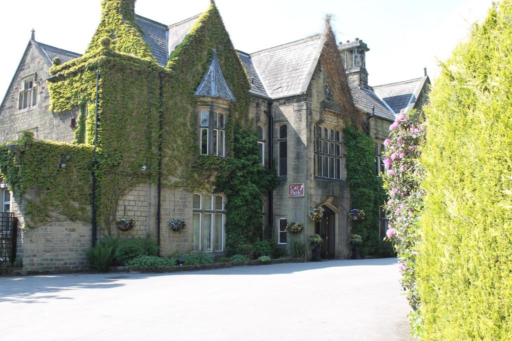 a large brick building with a clock on the side of it at Oakwood Hall Hotel in Bingley