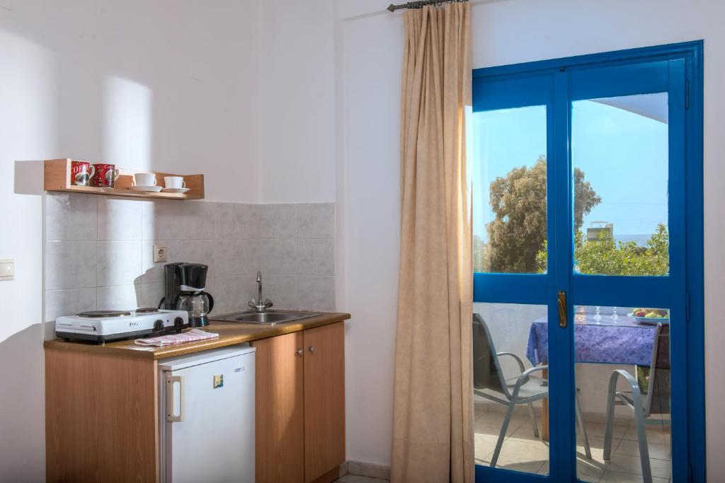 a kitchen with a door open to a kitchen with a window at Hotel Aglaia in Kalamaki