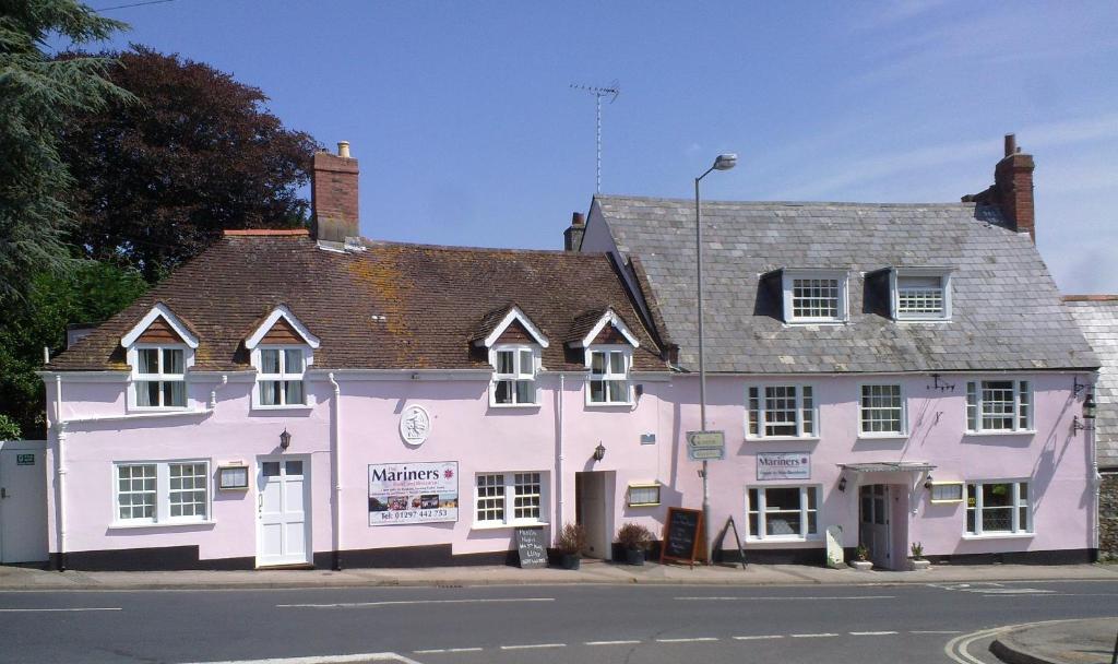 um edifício rosa na esquina de uma rua em The Mariners Hotel em Lyme Regis