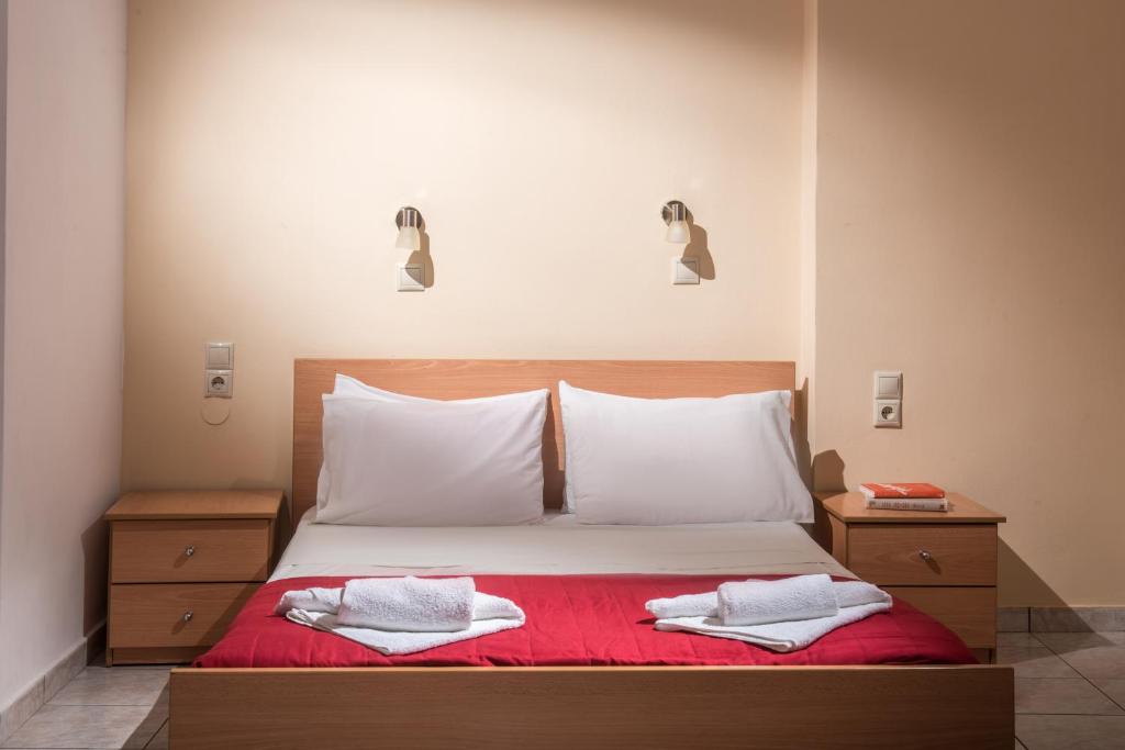 a bedroom with a bed with two towels on it at Hotel Aglaia in Kalamaki