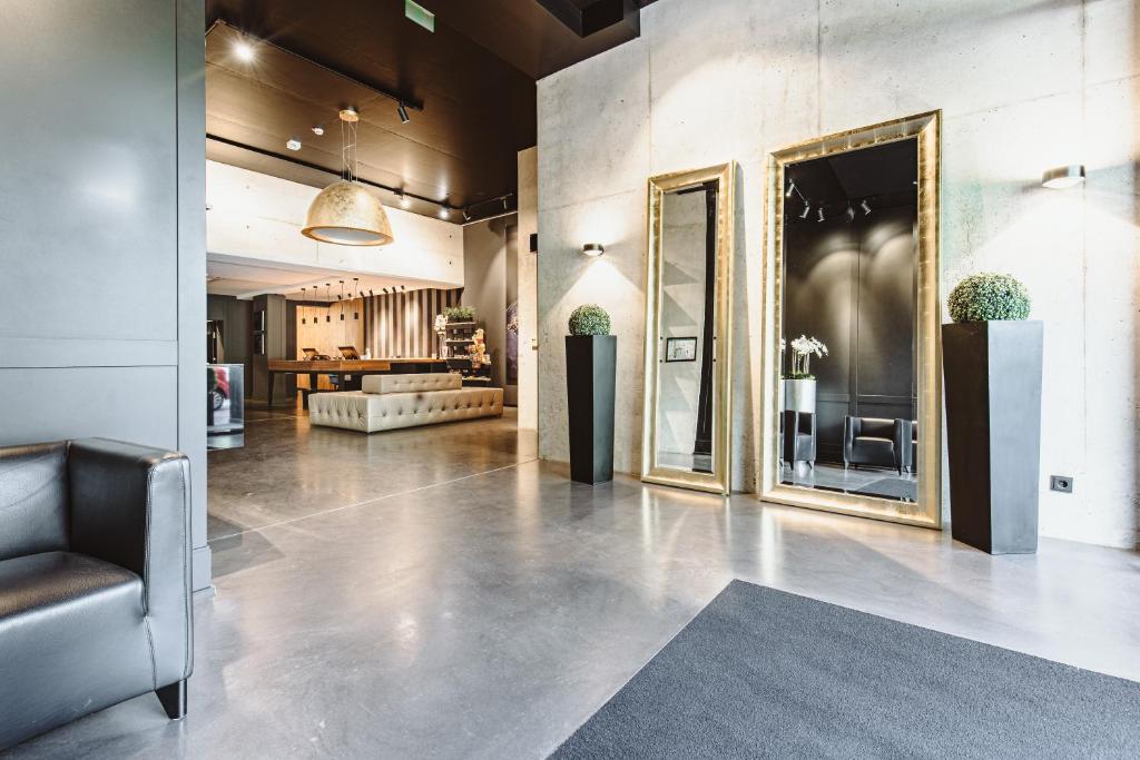 a lobby with two mirrors on the wall and a couch at &REPEAT Köln Airport in Cologne