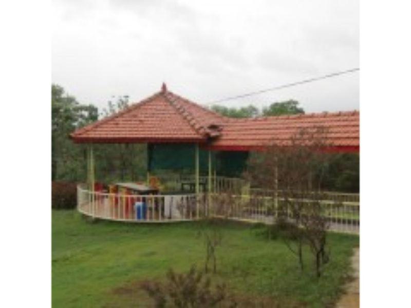 een prieel met een rood dak in een tuin bij Annapoorna Farms Villa 6Bhk in Khopoli