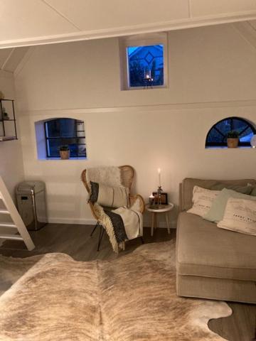ein Wohnzimmer mit einem Sofa und einem Stuhl in der Unterkunft B&B De Jagthut in Driel
