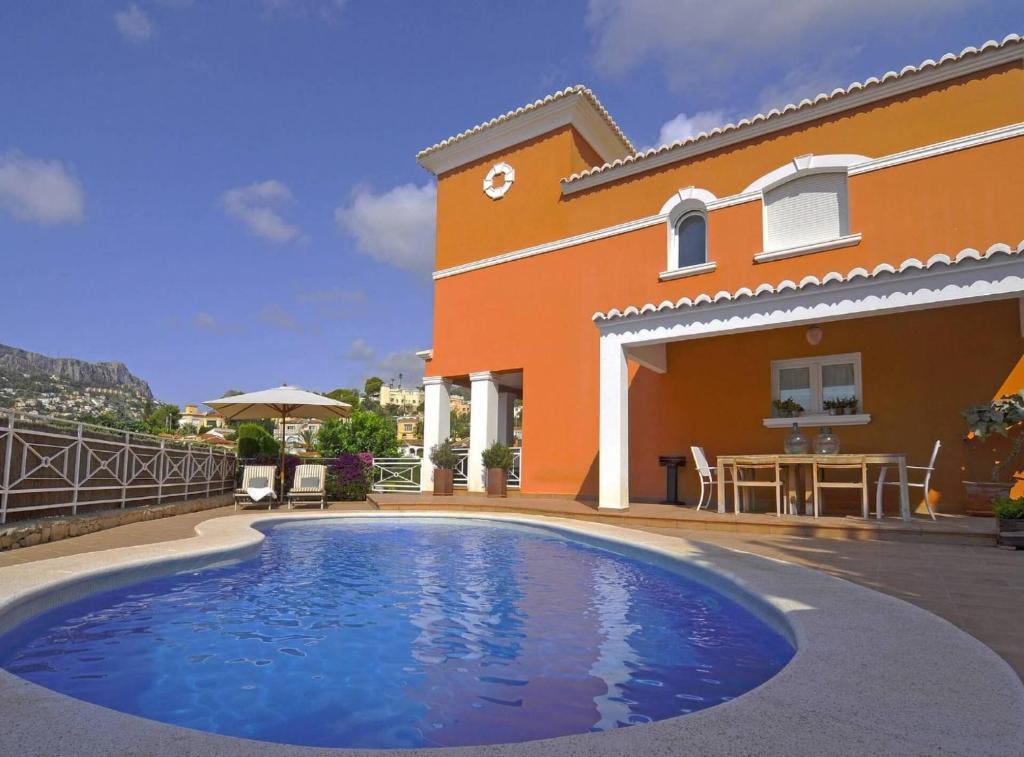 a swimming pool in front of a house at Villa Melissa - Plusholidays in Calpe