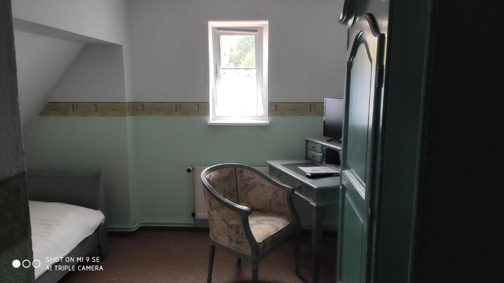 a room with a desk and a chair and a window at Lichtenberger Hof in Salzgitter