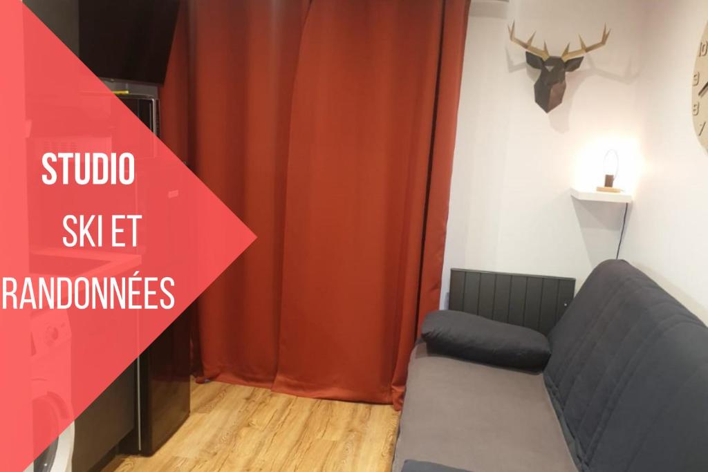 a room with a couch and a red curtain at Le 211,ski et randonnée, lave linge ,parking in Bernex