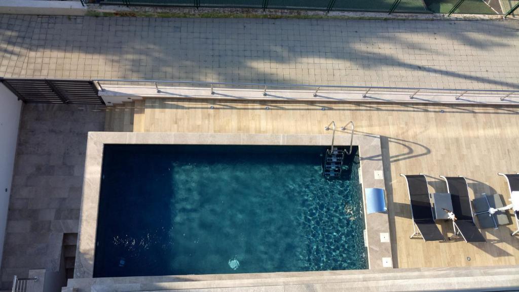 uma piscina com cadeiras ao lado de um edifício em Allegra Studio part em Pisak