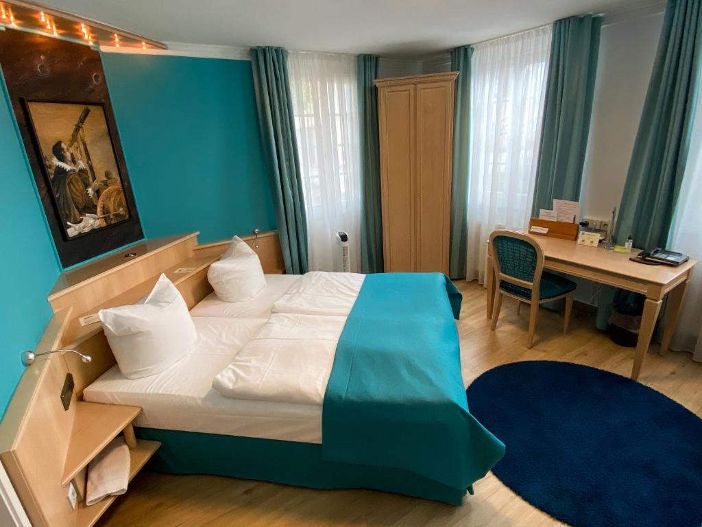 a hotel room with a bed and a desk with a desk at Hotel Am Schloss *** Superior in Tübingen