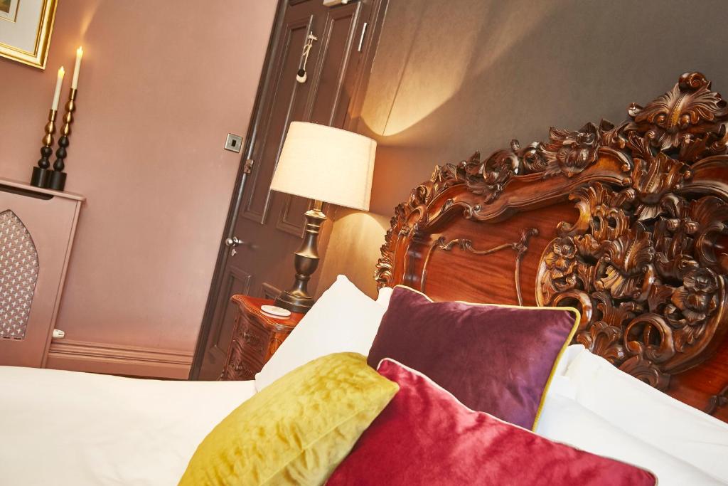 sypialnia z dużym drewnianym łóżkiem z poduszkami w obiekcie Dillons of Whitby w mieście Whitby