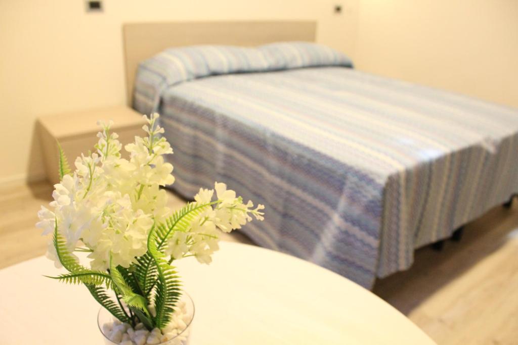 a bedroom with a bed and a table with flowers at Hotel la locanda di montecatone in Imola