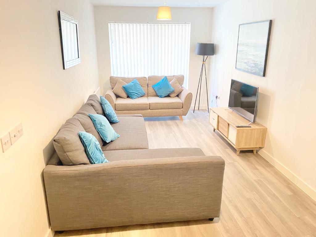 - un salon avec un canapé et une télévision dans l'établissement Halo Apartments - City Centre, à Manchester