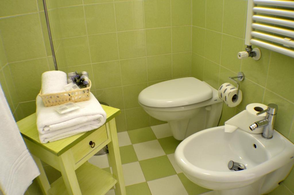 a green bathroom with a toilet and a sink at Masseria Asciano in Ostuni