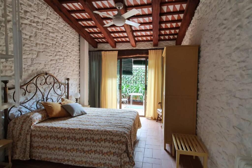 1 dormitorio con 1 cama y ventilador de techo en Ca la Caterina, en Peratallada