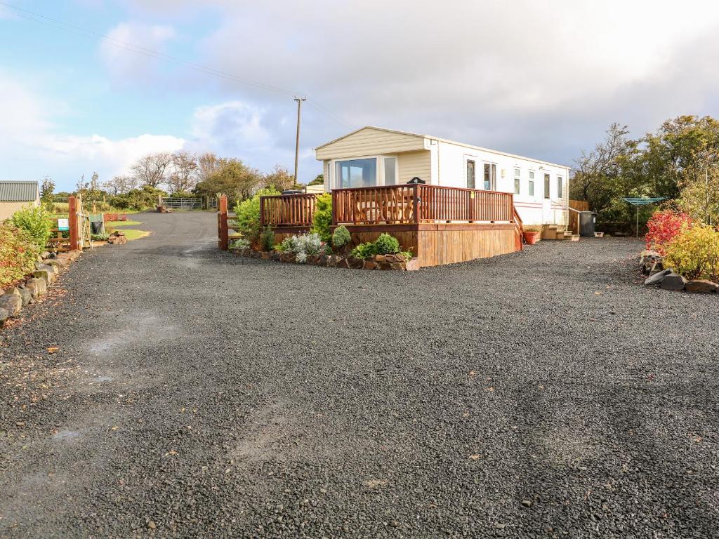 a house with a fence and a driveway at Alken Caravan in Bushmills