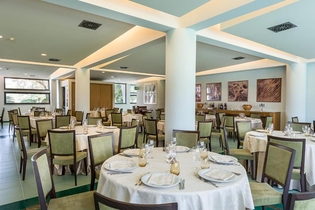 a dining room with white tables and chairs at Rada Siri in Montepaone