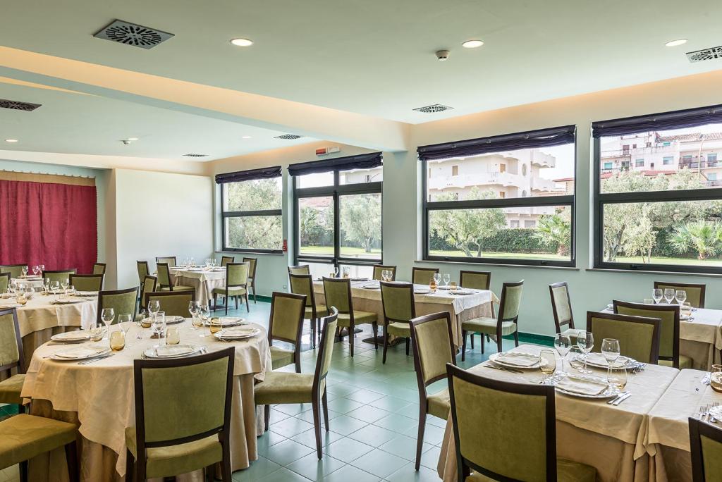 a dining room with tables and chairs and windows at Rada Siri in Montepaone