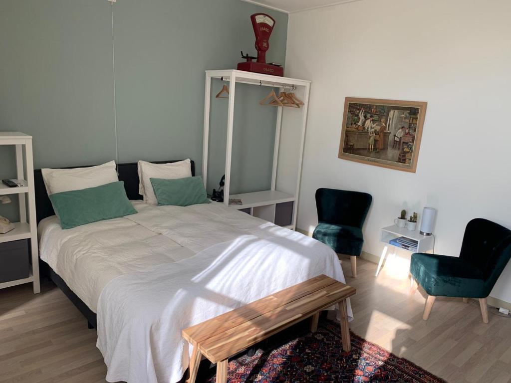 a bedroom with a large bed and two chairs at De Maecht van Mechelen in Zierikzee