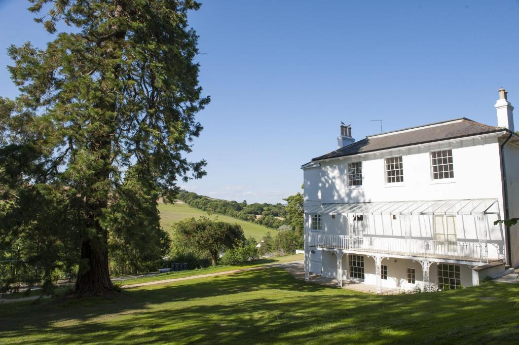 a large white house with a tree next to it at The Westgate in Charmouth