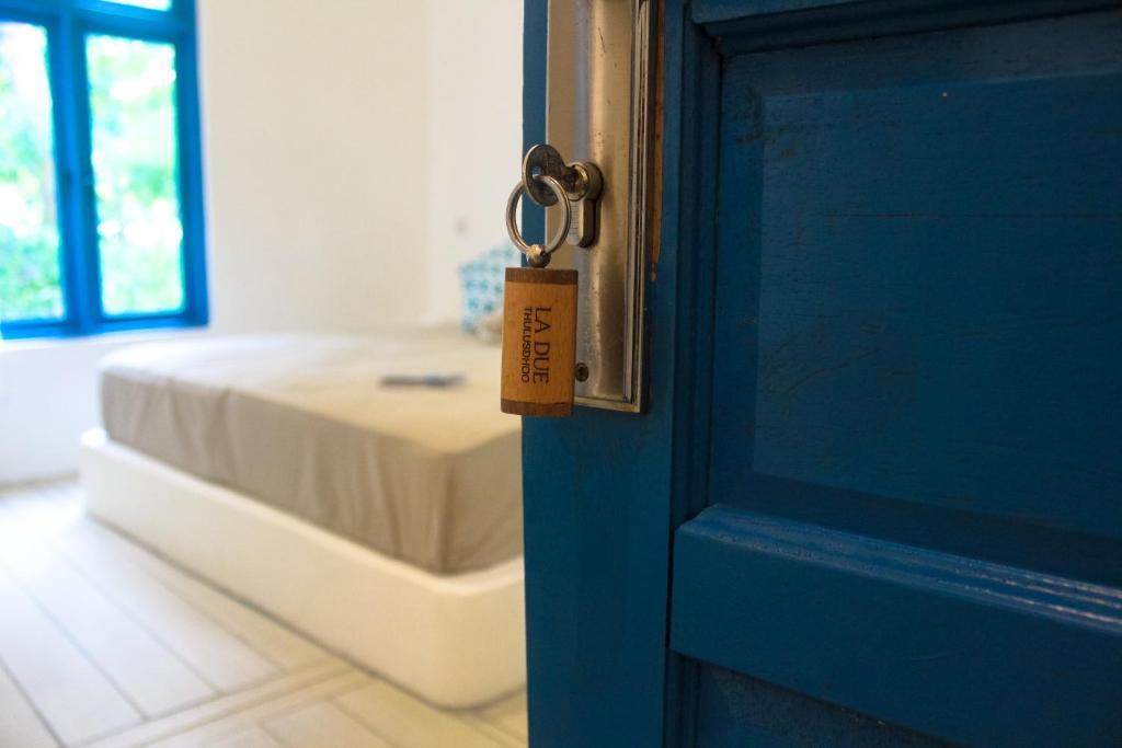 Una puerta con un llavero en una habitación con cama en La Due Thulusdhoo, en Thulusdhoo