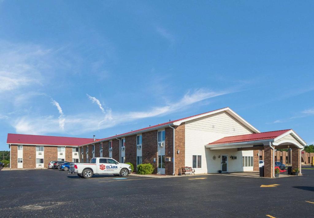 a building with a car parked in a parking lot at Econo Lodge Inn & Suites in Escanaba