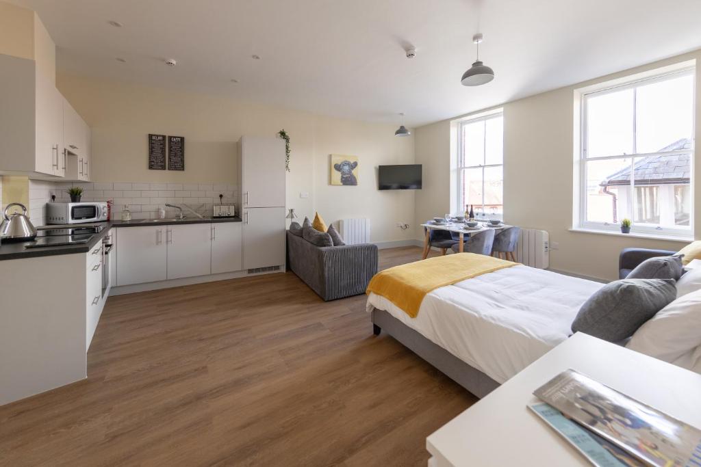 Apartment 6, Isabella House, Aparthotel, By RentMyHouse في هيريفورد: غرفة نوم بسرير ومطبخ وغرفة بها